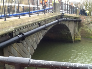 Photograph showing a water main on a bridge