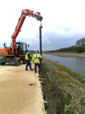 Photograph of work being done on a riverbank.